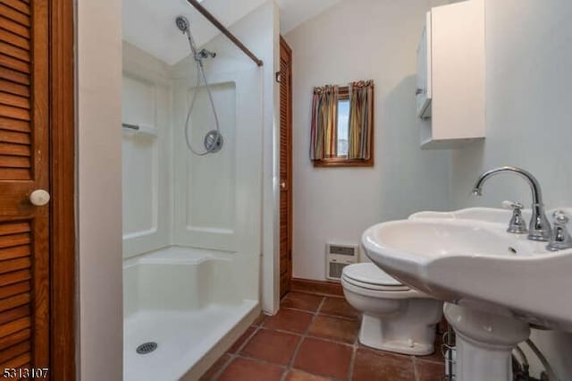 bathroom with a shower, tile patterned flooring, sink, and toilet