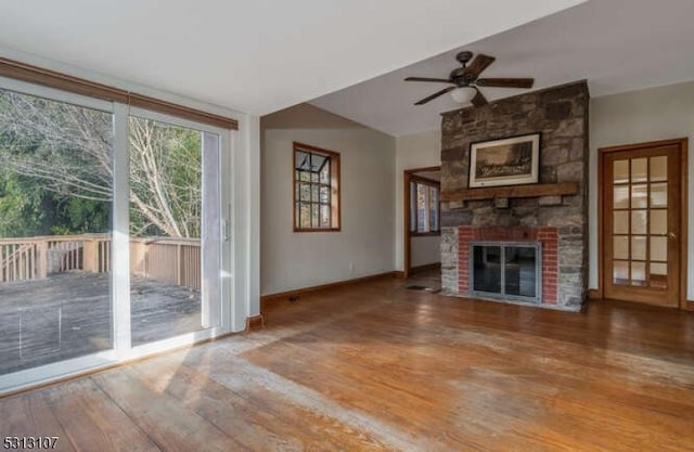 unfurnished living room featuring ceiling fan, wood-type flooring, and a brick fireplace