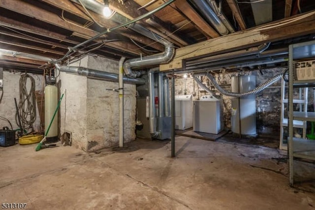 basement featuring water heater and washing machine and clothes dryer