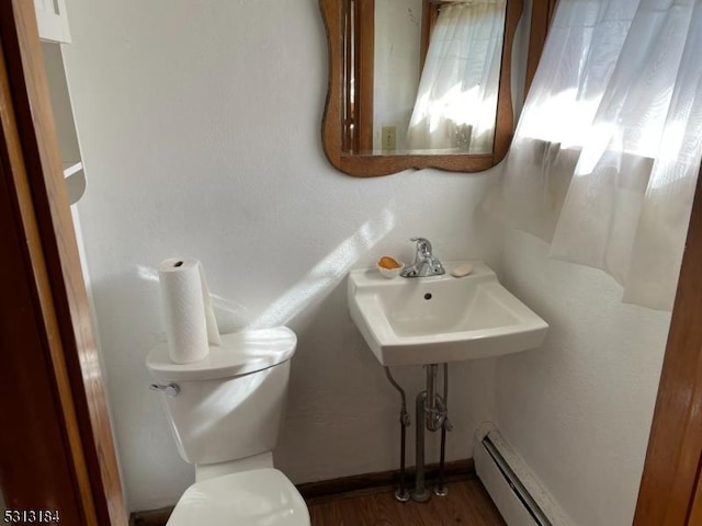 bathroom featuring hardwood / wood-style floors, sink, toilet, and baseboard heating