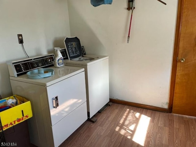 washroom with wood-type flooring and independent washer and dryer