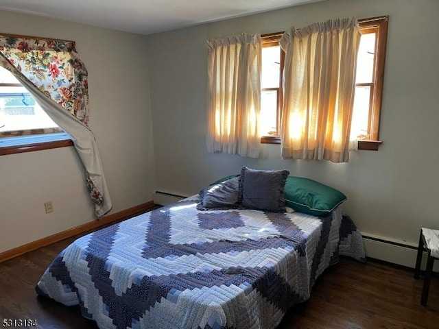 bedroom with dark wood-type flooring and a baseboard heating unit