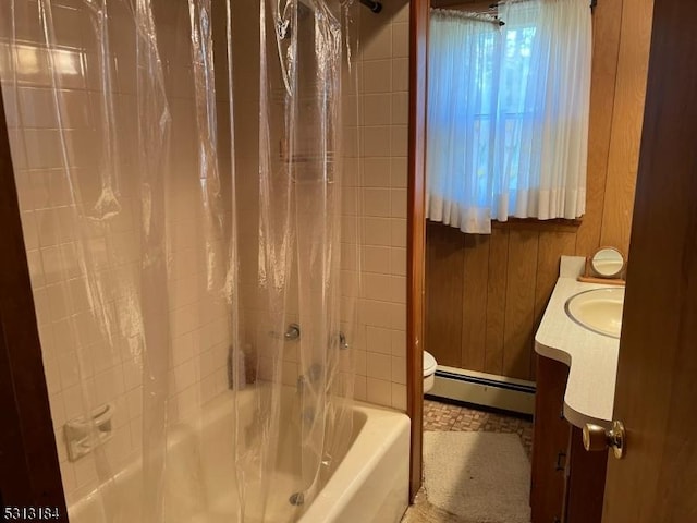 full bathroom with shower / tub combo with curtain, wood walls, vanity, a baseboard heating unit, and toilet