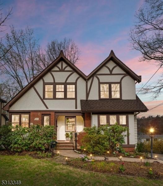 tudor home featuring stucco siding and brick siding