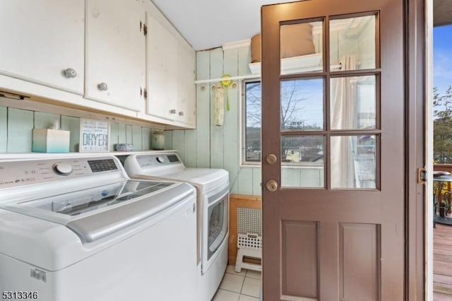 laundry room with light tile patterned flooring, plenty of natural light, separate washer and dryer, and cabinet space