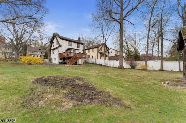 view of yard featuring fence, a deck, and stairs