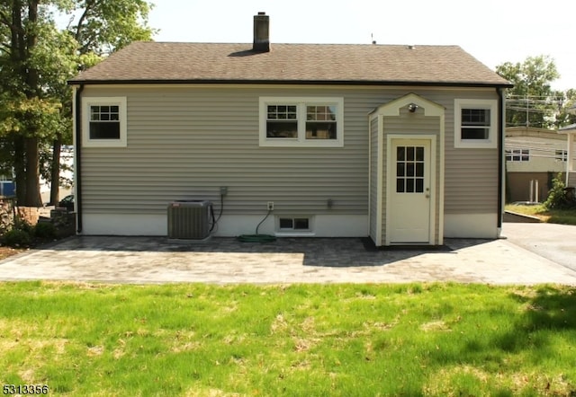 back of property featuring a patio, a yard, and central AC