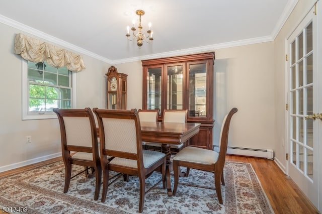 dining room with wood-type flooring, ornamental molding, a chandelier, and a baseboard radiator