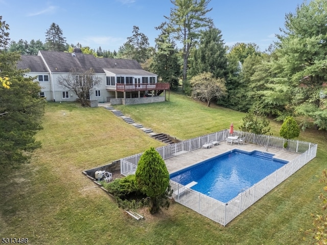 rear view of house with a yard and a swimming pool side deck