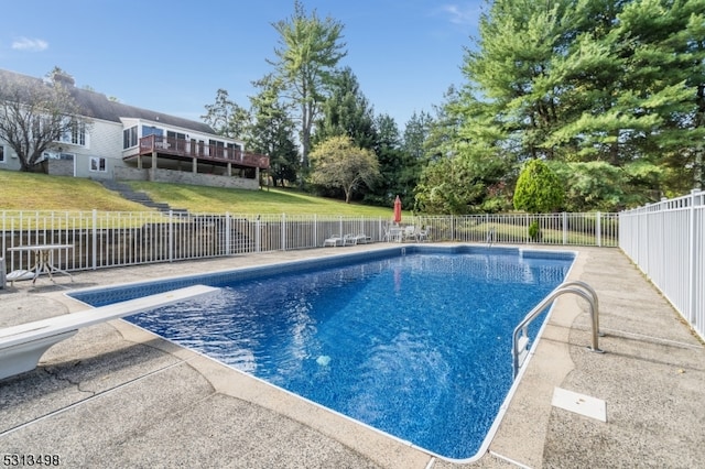 view of pool featuring a diving board and a yard