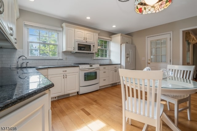 kitchen featuring white cabinets, sink, white appliances, backsplash, and light wood-type flooring