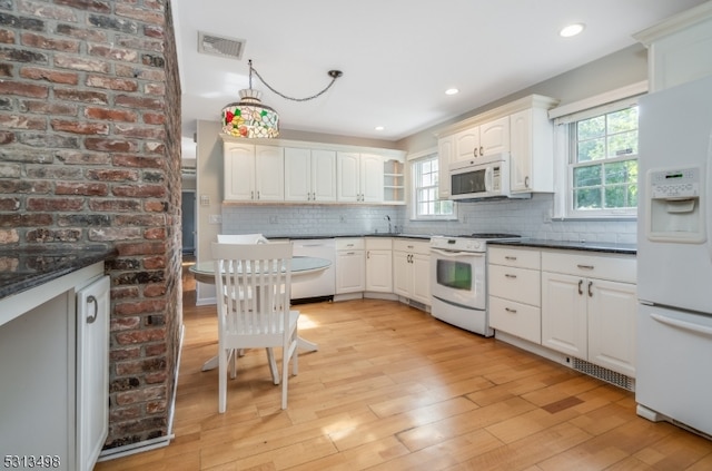 kitchen featuring plenty of natural light, light hardwood / wood-style floors, white appliances, and decorative backsplash