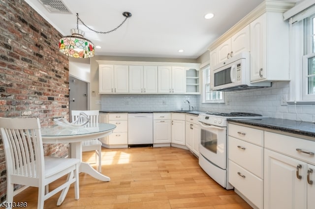 kitchen with decorative backsplash, white appliances, pendant lighting, and light hardwood / wood-style flooring