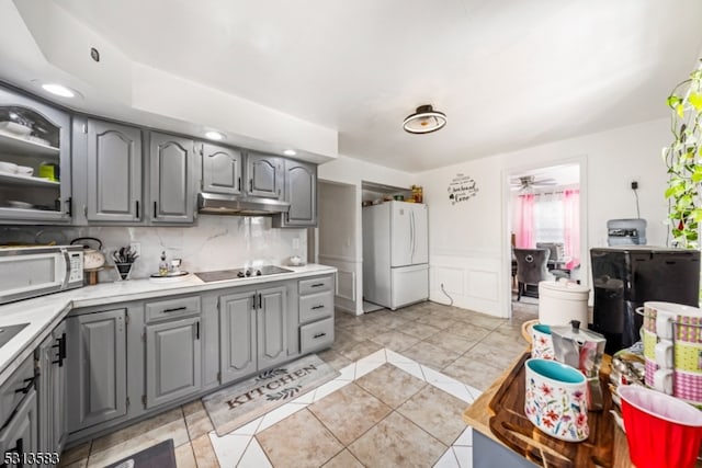 kitchen featuring gray cabinets, decorative backsplash, white appliances, and ceiling fan