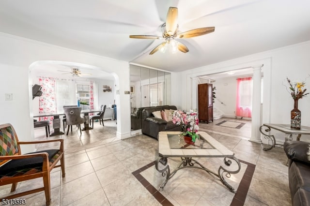 living room with crown molding, light tile patterned flooring, and ceiling fan