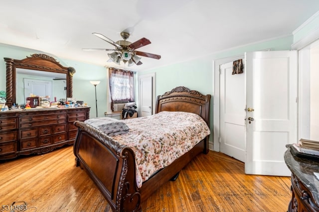 bedroom featuring ceiling fan, hardwood / wood-style floors, and crown molding