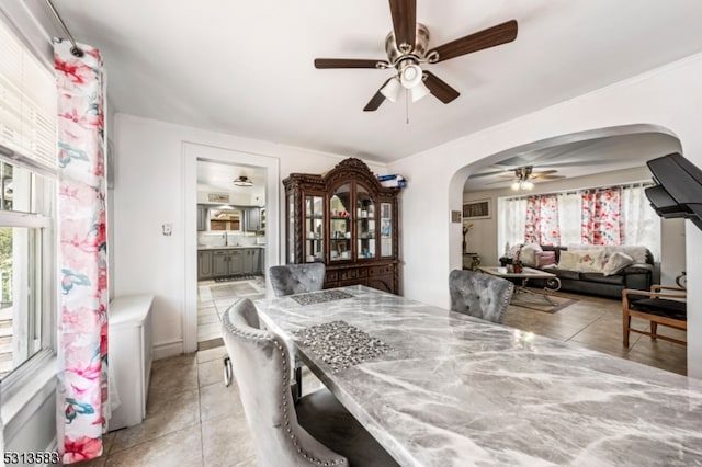 dining area with ceiling fan, light tile patterned flooring, and sink