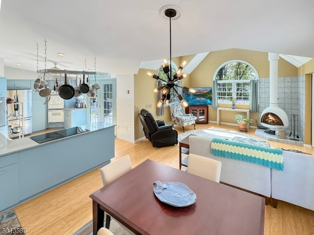 dining room with light hardwood / wood-style floors, lofted ceiling, and a chandelier