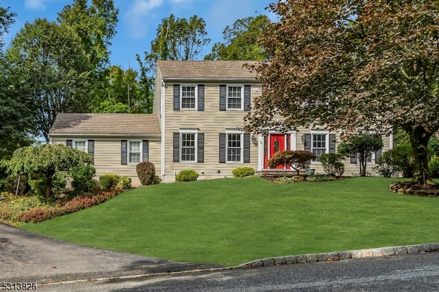 colonial home featuring a front lawn