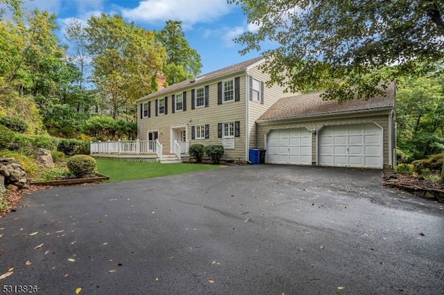 colonial house with a front yard and a garage