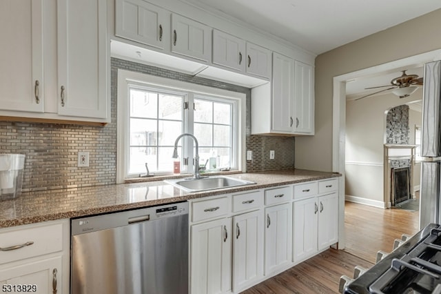 kitchen featuring light wood-type flooring, tasteful backsplash, white cabinetry, stainless steel appliances, and stone countertops