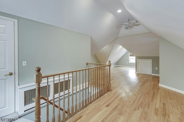 additional living space with light wood-type flooring and vaulted ceiling