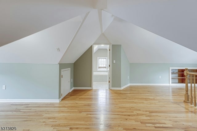 bonus room featuring light wood-type flooring and lofted ceiling