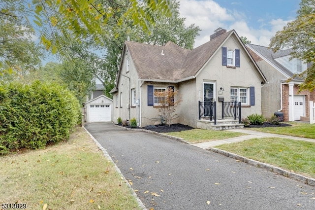 view of front of property with a front lawn, an outdoor structure, and a garage