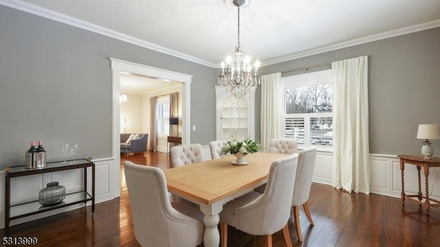 dining space featuring dark wood-type flooring, crown molding, and a chandelier