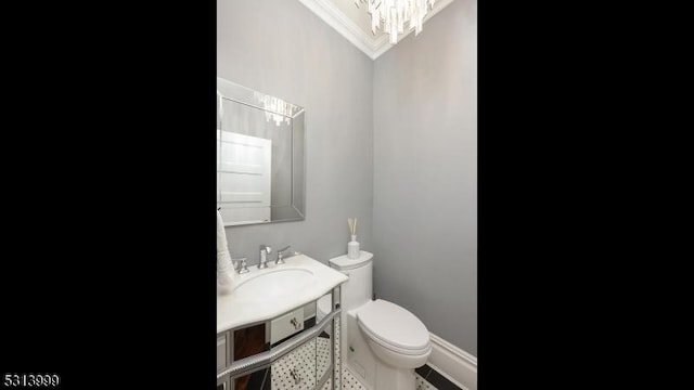 bathroom featuring sink, toilet, and a notable chandelier