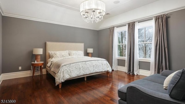 bedroom with dark hardwood / wood-style floors, ornamental molding, and a chandelier