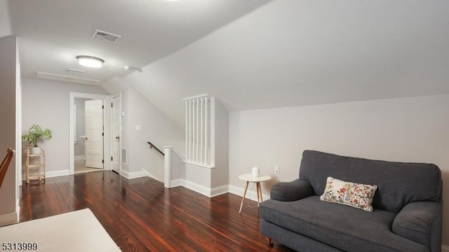 living area featuring vaulted ceiling and dark hardwood / wood-style flooring