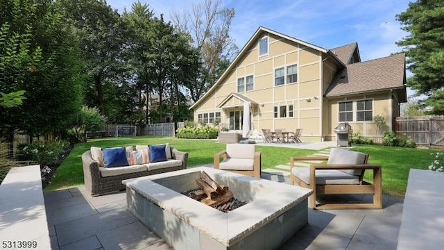 rear view of house featuring a patio area, a lawn, and an outdoor living space with a fire pit