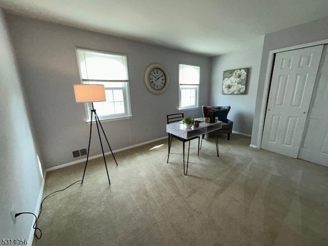 office space featuring visible vents, light carpet, and baseboards