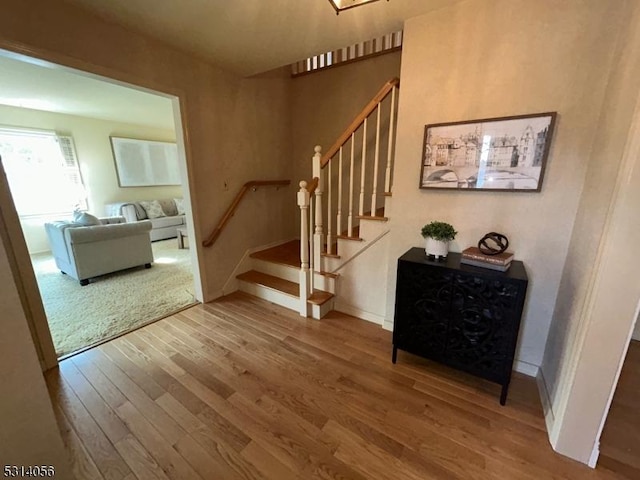 stairway with baseboards and wood finished floors