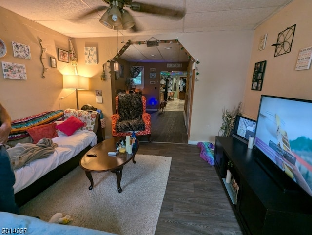 living room with a paneled ceiling, dark hardwood / wood-style floors, and ceiling fan