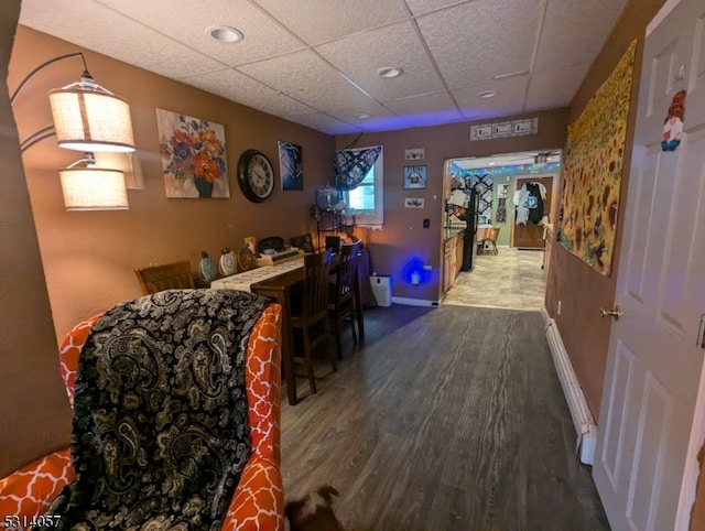 interior space featuring a drop ceiling and dark wood-type flooring