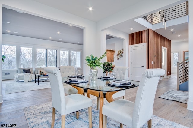 dining space featuring wood walls and light hardwood / wood-style floors