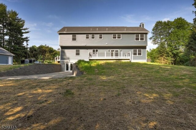 colonial home with a garage, a front lawn, and an outbuilding