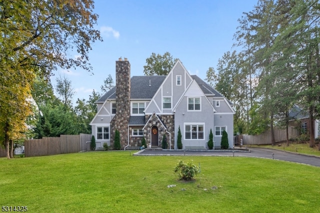 english style home featuring a front yard