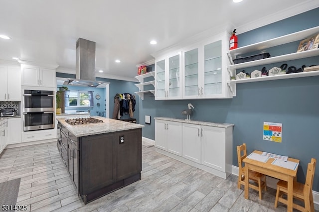 kitchen featuring a kitchen island, dark brown cabinets, white cabinetry, appliances with stainless steel finishes, and light hardwood / wood-style floors