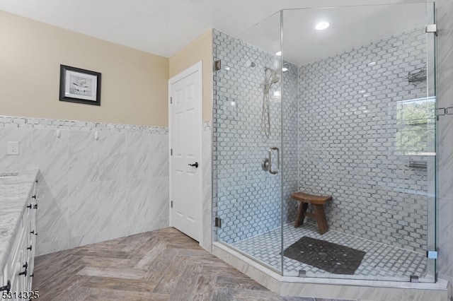 bathroom featuring vanity, tile walls, and a shower with shower door