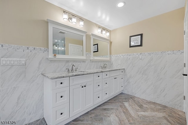 bathroom with tile walls, vanity, and parquet flooring