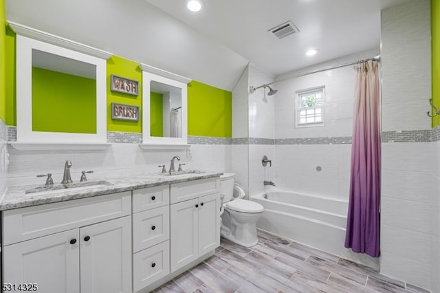 full bathroom with tile walls, vanity, shower / bath combo, hardwood / wood-style floors, and toilet