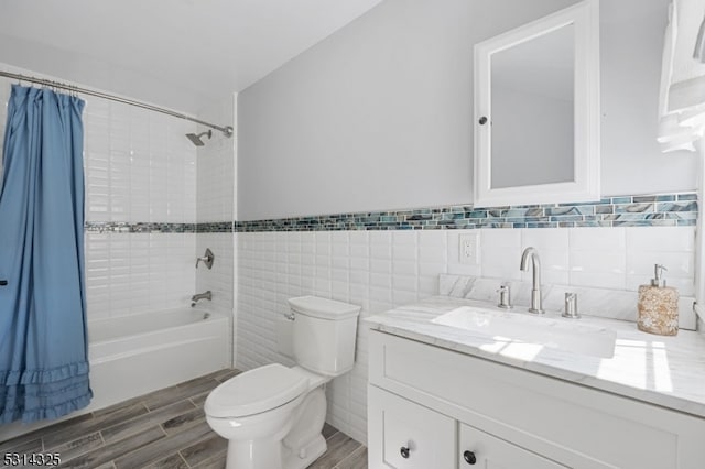 full bathroom featuring tile walls, wood-type flooring, shower / bath combo with shower curtain, vanity, and toilet