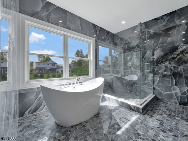 bathroom featuring independent shower and bath and tile walls