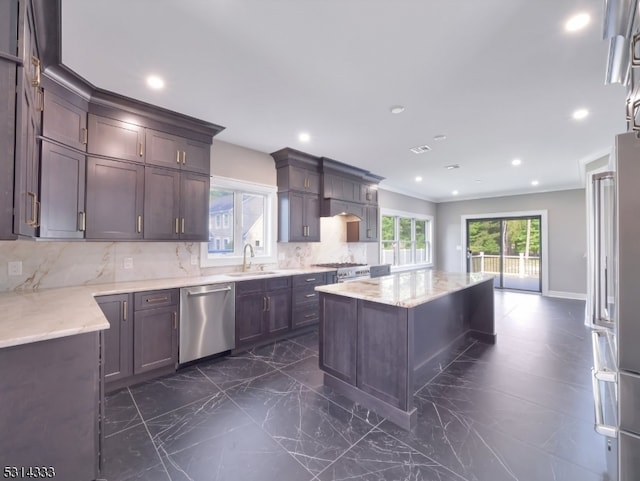 kitchen with dark brown cabinets, sink, a kitchen island, decorative backsplash, and appliances with stainless steel finishes