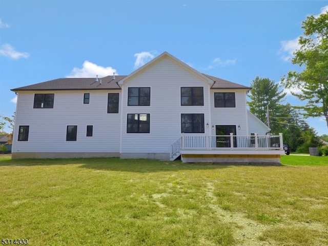 back of property with a lawn and a deck