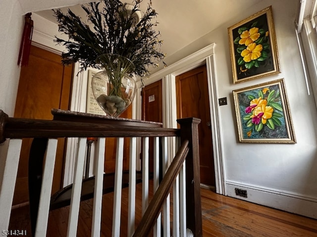 stairway featuring baseboard heating and hardwood / wood-style flooring