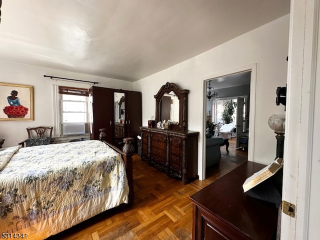 bedroom with cooling unit and dark parquet floors